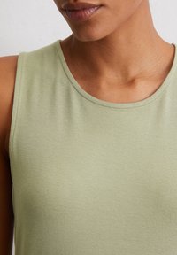 Light green sleeveless top featuring soft, lightweight fabric with a smooth texture and rounded neckline.