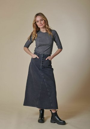 Dark denim maxi skirt with a high waist, front button closure, and side pockets. Paired with a fitted gray long-sleeve top and black ankle boots.