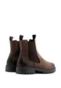 Brązowe skórzane botki Chelsea z elastycznymi bokami, uchwytami do zakupu oraz teksturowaną gumową podeszwą z wytrzymałym wzorem bieżnika.