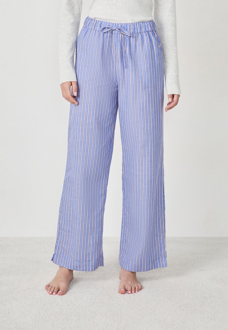 Pantalons larges bleu clair avec des rayures verticales blanches et roses, dotés d'une taille élastique avec un cordon de serrage décoratif.