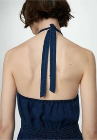 Tmavě modré šaty na ramínka s detailem zavazování na zádech a elastickým pasem. Tkanina vypadá hladce a lehce, s přiléhavým střihem.