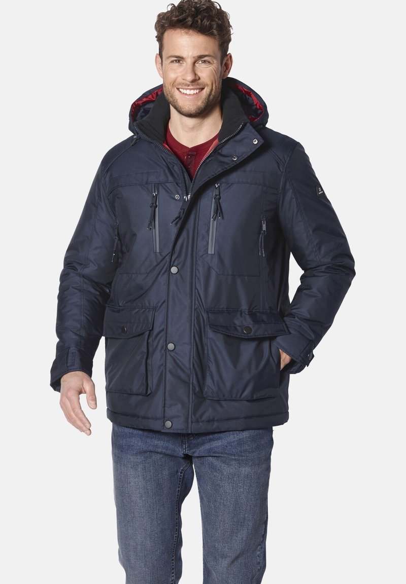 Marineblau gesteppte Jacke mit einer kontrastierenden Kapuze, Fronttaschen und Reißverschlüssen. Verfügt über eine robuste Stoffstruktur und Knopfverschlüsse.