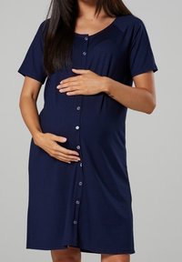 Marinblå knäppklänning för gravida med korta ärmar, mjukt tyg, figursydd design och rundad halsringning. Har en slät yta.
