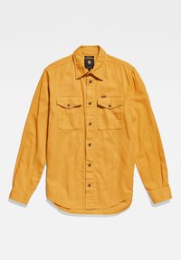 Camicia a maniche lunghe gialla in cotone. Presenta due tasche sul petto, chiusura con bottoni e orlo arrotondato. Vestibilità leggermente rilassata.