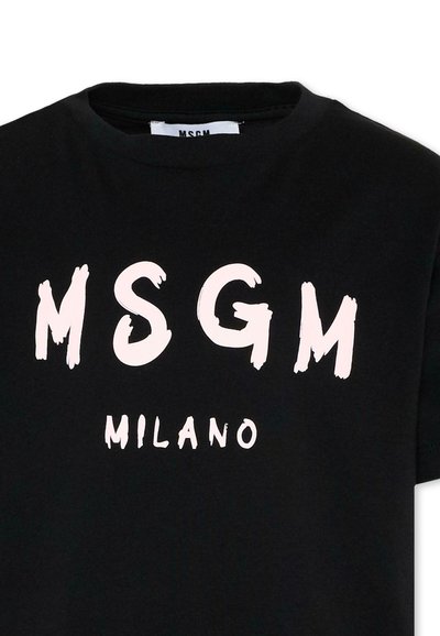 T-shirt noir avec de grandes lettres blanches MSGM au-dessus d'un texte blanc plus petit MILANO sur le devant, montrant l'encolure et une partie des manches.