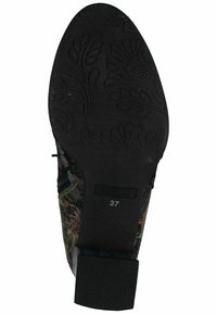 Suela texturizada negra de un zapato con un patrón floral, con una parte superior multicolor y una etiqueta de tamaño visible '37'.