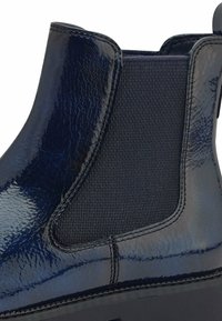 Bottine Chelsea bleu marine avec dessus en cuir poli, panneau latéral élastique, section en tissu texturé et détail de couture renforcée.