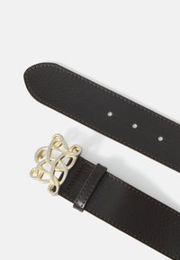 Dunkelbrauner Leder Gürtel mit strukturierter Oberfläche und dekorativer gold- und silberfarbener, miteinander verwobener keltischer Knoten Schnalle auf weißem Hintergrund.