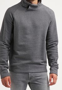 Harmaa poolopaita, jossa on korkea kaula-aukko, raglan-hihat ja joustavat hihansuut. Pehmeä pinta hienovaraisella neulekuviolla.