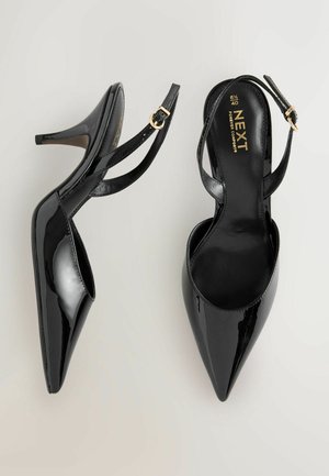 Melni lakādas augstpapēžu apavi ar smailu purngalu, atvērtu aizmuguri un regulējamu potītes siksniņu; ar zelta toņa sprādzes dekoru.