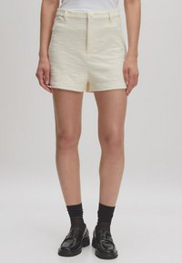 Crème-kleurige, gestructureerde shorts met een hoge taille en sluiting aan de voorkant, met een rechte snit en een zoom op dijhoogte.