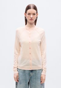 Ροζ ανοιχτό ροζ ζακέτα από μαλακό υλικό, με στρογγυλή λαιμόκοψη, κούμπωμα με κουμπιά και ριμπ τελείωμα. Μακριά μανίκια με άνετη εφαρμογή.