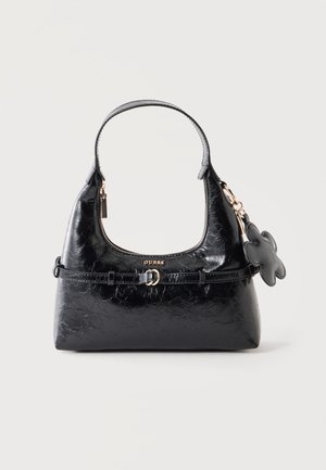 Sac à main noir brillant Guess avec poignée supérieure, petit charm fleur attaché, détail de boucle sur le devant et fermeture éclair dorée sur fond blanc.