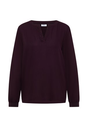 Długi rękaw w głębokim purpurowym materiale, z dekoltem w kształcie litery V ozdobionym przeszyciami oraz marszczonymi mankietami. Prosty i luźny krój.