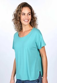 Türkises Kurzarmoberteil aus weichem Stoff, mit weit ausgeschnittenem Hals und abgerundetem Saum mit seitlichen Schlitzen. Einfaches, lässiges Design.