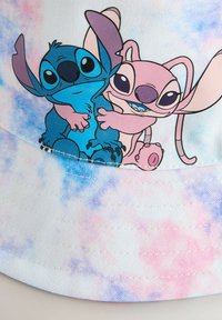 Chapeau seau avec un design tie-dye pastel, présentant des personnages de dessins animés bleus et roses s'enlaçant à l'avant. Fabriqué en tissu texturé.