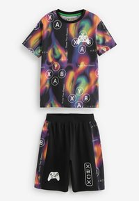 Outfit a tema videoludico per bambini, composto da una maglietta a maniche corte con motivi a vortice colorati e pantaloni corti neri abbinati con loghi Xbox.