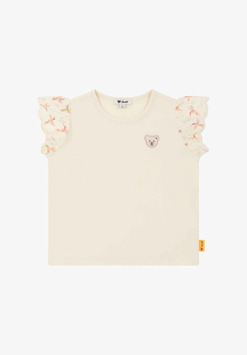 Krémové tričko s krátkými, řasenými rukávy, vyzdobené květinovým vzorem. Na hrudi je vyšitá nášivka s obličejem medvídka. Měkký bavlněný materiál.
