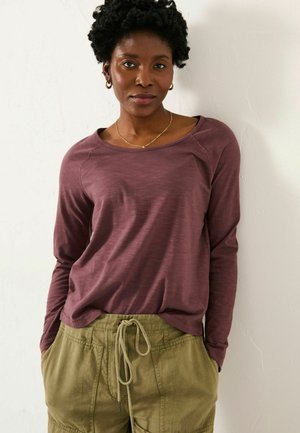 Long-sleeve, maroon shirt with a relaxed fit and rounded neckline, paired with olive green cargo pants featuring a drawstring waist.