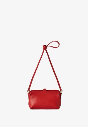 Bolso cruzado de cuero rojo con una larga correa ajustable y un detalle de asa en forma de lazo, diseño minimalista con cierre frontal.