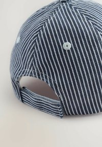 Cappello a strisce in tessuto blu navy e azzurro chiaro con visiera curva, cinturino regolabile sul retro e dettagli cuciti lungo le cuciture.