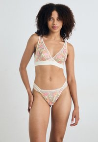 Bralette met kantafwerking en bloemenborduursel in pastelkleuren, gecombineerd met bijpassende string, met zachte stof en delicate details.