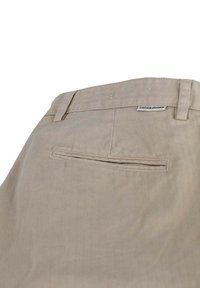 Beige Jack & Jones trousers with a herringbone texture, featuring a back pocket and a branded label above the waistline.