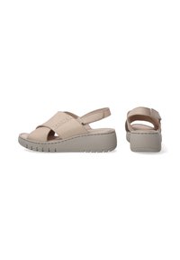 Beige wedge sandalen met een gekruist ontwerp, verstelbare achterband, een gestructureerde zool en gestikte accenten voor extra detail.