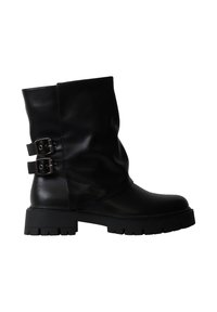 Botte en cuir noire mi-mollet avec deux boucles latérales et une semelle épaisse à crampons, vue de profil côté extérieur.