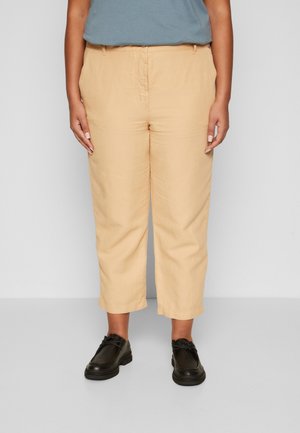 Tan cropped pants met een rechte pijp, gemaakt van een lichtgewicht stof, met een voorrits en zijzakken. Gecombineerd met zwarte schoenen.