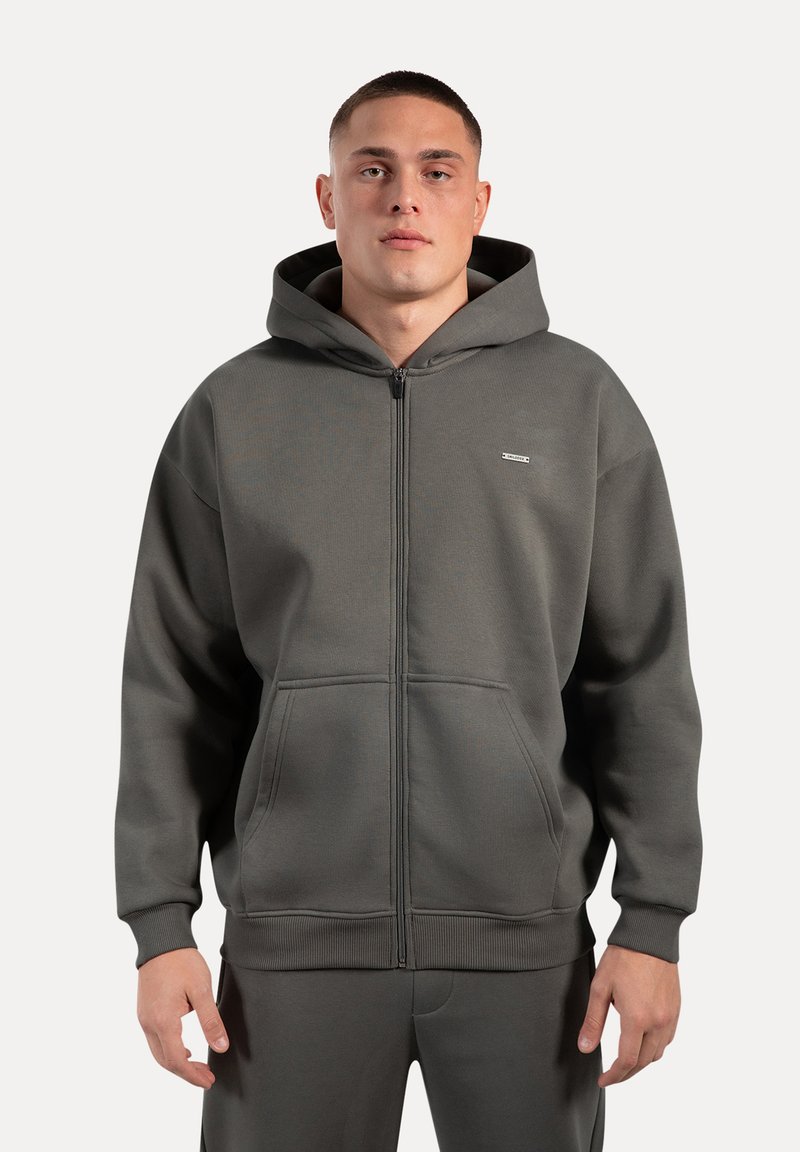Grå lynlås hoodie lavet af tekstureret stof. Har en stor hætte, frontlommer og elastiske manchetter. Diskret logo på brystet.