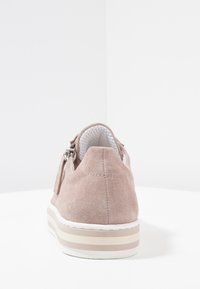 Różowe zamszowe sneakersy z okrągłym noskiem, gładką białą podeszwą i dekoracyjnym bocznym zamkiem, z teksturowaną wkładką i minimalistycznym designem.