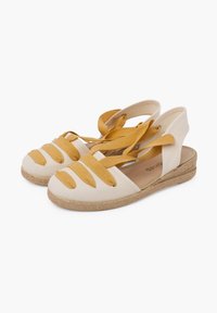 Beige plátěné espadrilky se žlutými popruhy a otevřenou patou. Mají tkanou jutu podrážku a zaoblený tvar špičky.