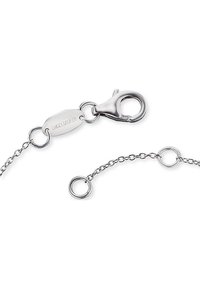 Collana con chiusura in metallo argentato, dotata di maglie a catena e un'etichetta con logo. Presenta una chiusura a granchio e dettagli in anelli circolari per una lunghezza regolabile.