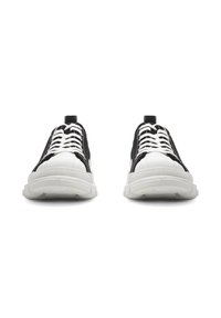 Białe i czarne trampki z teksturowaną gumową podeszwą, z gładką cholewką, kontrastującym szyciem oraz okrągłymi sznurówkami.