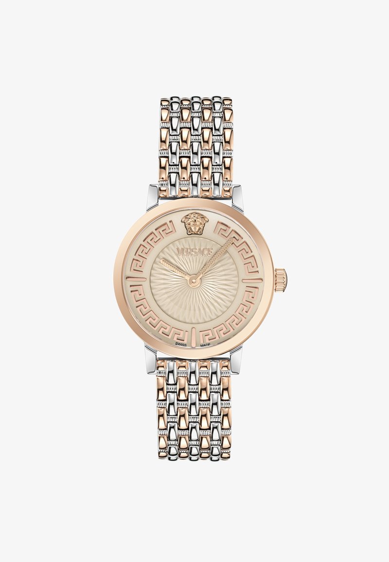 Versace kell, millel on ümmargune beež kellanägu Kreeka võtme mustriga, kuldsetoonilised lisandid ja mitmevärviline metallist võrgurihm.