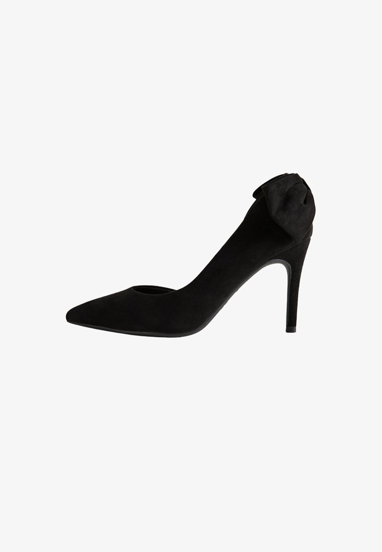Décolleté nera in suede con tacco alto, punta affilata e dettaglio di fiocco decorativo sul tallone.