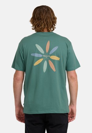 Grünes T-Shirt mit kurzen Ärmeln, das auf der Rückseite ein farbenfrohes Surfbord-Motiv in einem Blumenarrangement zeigt. Aus weichem Baumwollmaterial.