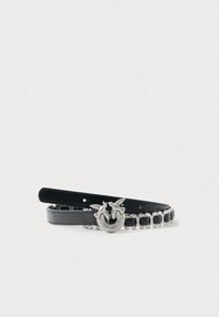 Cintura in pelle nera con una fibbia metallica argentata che presenta due uccelli e decorazioni in cristallo, arricchita da catene decorative.