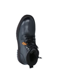 Bota de cuero negro con un upper texturizado, punta redonda y forro de piel. Presenta cordones, ojales de metal y una lengüeta trasera para facilitar el calzado.