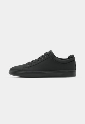 Schwarze Sneaker mit einer glatten Oberseite aus Stoff, runder Zehenpartie und strukturierten Akzenten; verfügen über flache Schnürsenkel und eine gepolsterte Sohle für zusätzlichen Komfort.