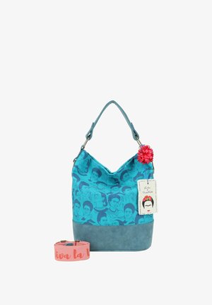 Tegen kleur stoffen tas met illustraties van Frida Kahlo, textuur blauwe bodem, verstelbare strap en een roze bloemenaccent. Inclusief een roze strap met tekst.