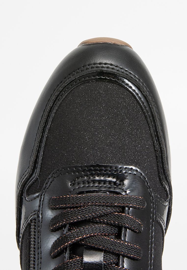 Czarne buty sportowe z teksturowaną cholewką z płótna i błyszczącymi akcentami z lakierowanej skóry. Posiadają czarne sznurowadła oraz okrągły kształt noska.