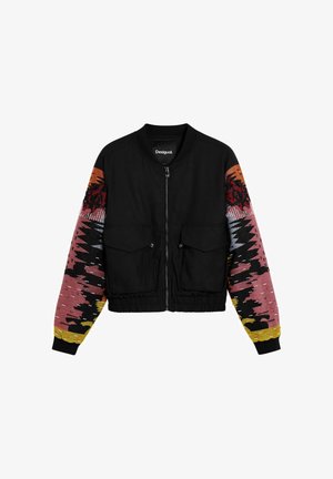 Must trummi jope mitmevärviliste mustriliste varrukatega, esiküljel taskud ja tõmblukuga sulgur. Tekstuuriga kangas kontrastsete värvidega.