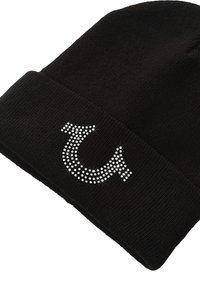 Zwarte gebreide muts met een gebogen logo van zilveren rhinestones. Glad textuur met een omgeslagen boord aan de basis.