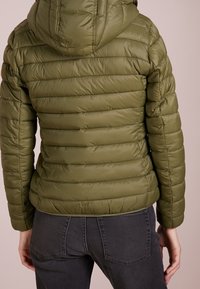 OLivengrøn puffjakke med vandret kviltet mønster, tætsiddende pasform og fast hætte. Materialet har en glat, blank tekstur.