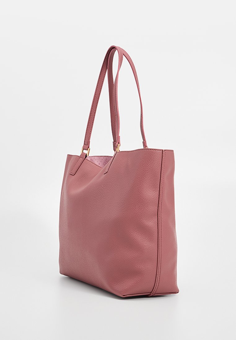 Bolso de tote texturizado en color rosa con dos asas largas, que presenta una base plana y hardware mínimo. Material suave y liso con un diseño simple.