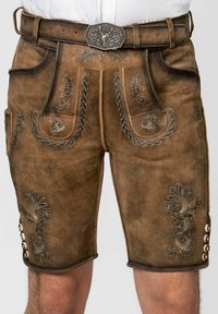 Skórzane lederhosen w kolorze brązowym, z srebrnymi haftami, ozdobnymi kieszeniami oraz metalową klamrą z motywem jelenia. Dodatkowe guziki po bokach.