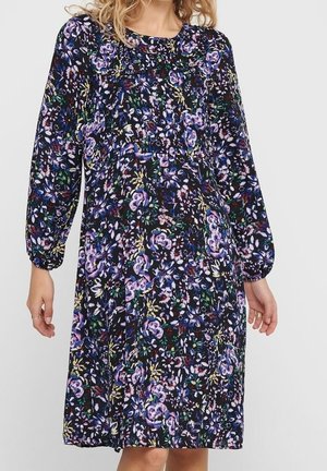 Robe noire à motif floral avec des manches longues, un col rond et une taille froncée. Présente des accents de violet, rose et vert partout.
