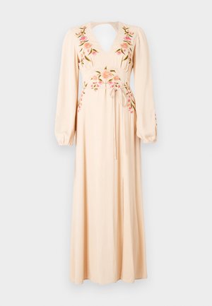 Robe longue de couleur rose pâle avec des manches longues, un décolleté en V, brodée de fleurs roses et vertes, et une taille à nouer. Comprend une fente sur le devant.